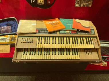 Eski org, yastıklı ahşap bank, kitaplar ve kırmızı bir klasör, kırmızı gitarın bir parçası, loş ışıklandırma, gizli fotoğraf tarzı Kyiv, Ukrayna 06-19-2022