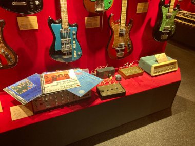 Klasik müzik aletleri elektrikli gitarlar, kayıt albümleri, kırmızı kadifede sergilenen amplifikatörler, çeşitli bitişler mavi, kahverengi, siyah, beyaz yumuşak gölgeler, savaş Kyiv, Ukrayna 06-19-2022