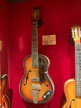 Kırmızı arka planda klasik akustik gitar, iyi korunmuş bitiş, keçeli kalem, yankesici, açılı perspektif Kyiv, Ukrayna 06-19-2022