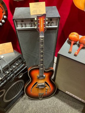 Elektro gitar titreşimli kırmızı, çoklu düğmeler, anahtarlar, sıcak bir iç mekanda halı döşeli iki pikap, kısmen görünür müzik aletleri ve ekipmanlar Kyiv, Ukrayna 06-19-2022