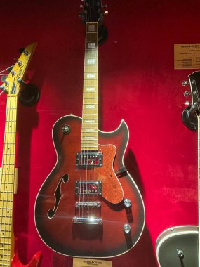 Kırmızı kadife bir gitar koleksiyonunun yakın plan çekiminde yarı akustik gitar, dört kontrol düğmesi, iki pikap, fret mar Kyiv, Ukrayna 06-19-2022