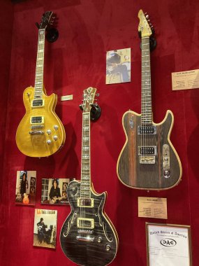 Benzersiz tasarım ve renk şemalarına sahip dört elektro gitar kırmızı kadife bir arka planda sergilenen doğal, siyah, sarı, içi boş ve katı vücut modu Kyiv, Ukrayna 06-19-2022
