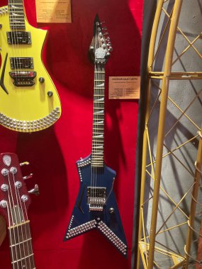 Kırmızı bir yüzey üzerinde sergilenen elektro gitar koleksiyonu, çeşitli dizaynlar sarı, mavi, turuncu ve desenler Mavi gitar B Kyiv, Ukrayna 06-19-2022