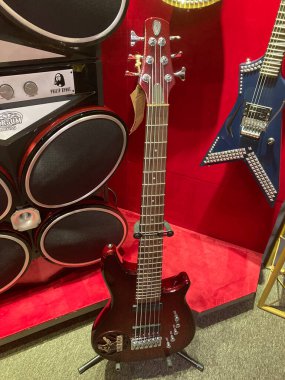 Kırmızı elektro gitar ve davul setinin yer aldığı yakın plan müzik seti daha koyu yankesicilik alanı olan kırmızı gitar, çoklu telli Brownblack davul seti, muhtemelen Kyiv, Ukrayna 06-19-2022