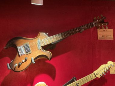 İki elektrikli gitar, biri askıya alınmış, kahverengi ve krem rengi gümüş donanımlı gitarlara karşı sergilenen dört kontrol düğmesi, iki Kyiv, Ukrayna 06-19-2022