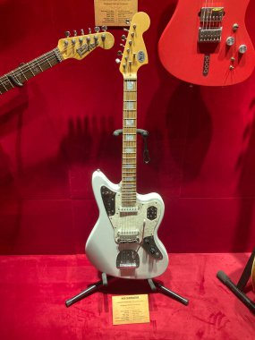 Sergilenen elektro gitar koleksiyonunun yakın çekimi, ağırlıklı olarak ahşap, ön planda kırmızı bir gitar, boynu yukarıya dönük diğer gitarlar Kyiv, Ukrayna 06-19-2022