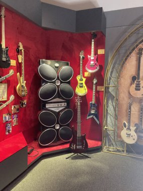 Beyaz-kırmızı arkaplanda elektrikli gitar ve davul gösterimi, bir müze sergisi veya mağaza ortamında sergileniyor, parlak ışıklandırma ve metin veya insan yok Kyiv, Ukrayna 06-19-2022
