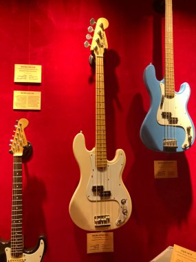 Elektro gitar koleksiyonu yatay ve dikey olarak kırmızı sahne arkası gitarları arasında açık mavi olanı dik, biri aşağı doğru, c Kyiv, Ukrayna 06-19-2022