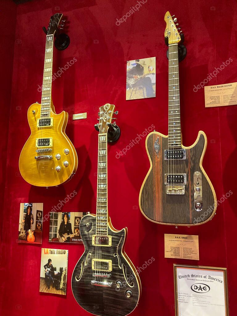 Four electric guitars with unique designs and color schemes natural, black, yellow, natural displayed on a red velvet backdrop Semi-hollow body and solid body mod Kyiv, Ukraine 06-19-2022