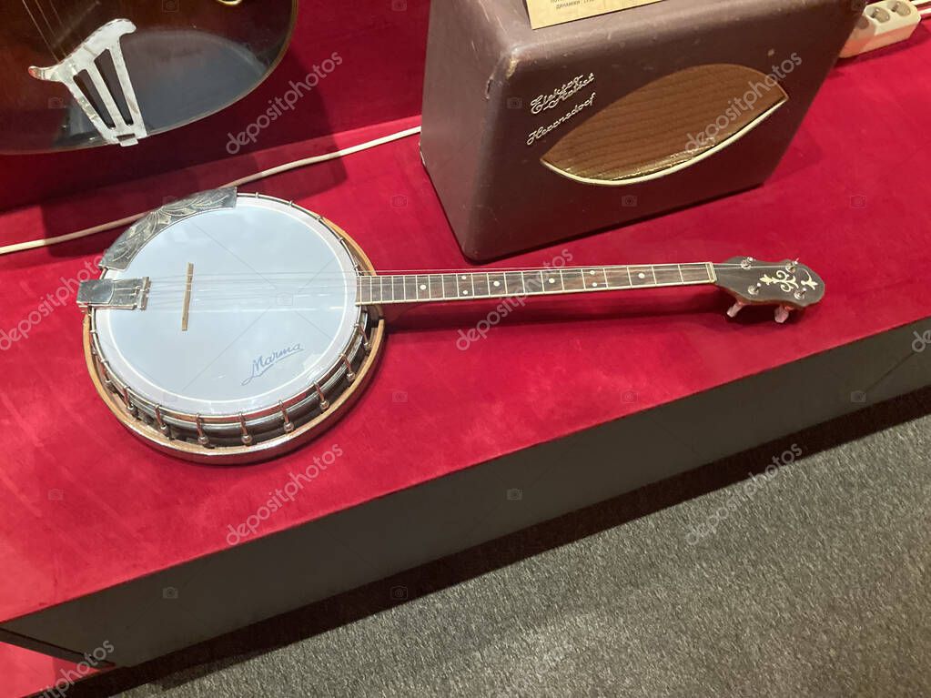 Image of a musical instrument display area with a centered dobro guitar and an old-fashioned amplifier The guitar has a wood finish, and the amplifier is vintage wi Kyiv, Ukraine 06-19-2022