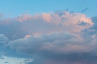 Geniş gökyüzü pembe, turuncu kümülüs ya da güneş tarafından aydınlatılan kümülonimbus bulutlarla dolu. Gün batımında, doğal manzara filtresiz gerçekçidir.