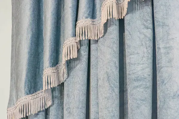 Mavi, çizgili perdelerin yakın çekimleri, kenarlık detaylarıyla, kısmen açık, belirsiz oda içini gösteriyor. Straigh 'in ışıklandırmasıyla önerilen metin veya ayırt edilebilir nesneler yok.