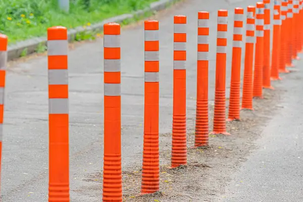 Turuncu ve beyaz trafik konileri ile işaretlenmiş kentsel caddenin önü iş yeri nedeniyle kapalı alanla iyi korunmuş kentsel binalar arka planda gerçekçilik tarzı