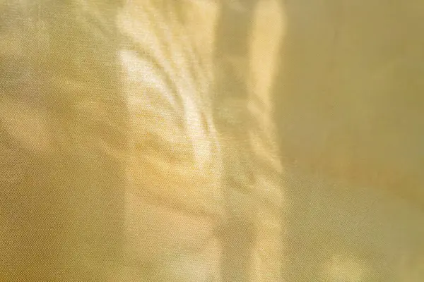 Kumaştan ya da metalden örülmüş ışık ve gölge etkileşimi, ince sarımsı yeşil arkaplan doğayı işaret ediyor..