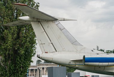 Sabit beyaz bir uçak havaalanının pistinde, arka planında ağaçlar olan görünür metin ya da insanların bulutlu aydınlatma koşulları olmayan.