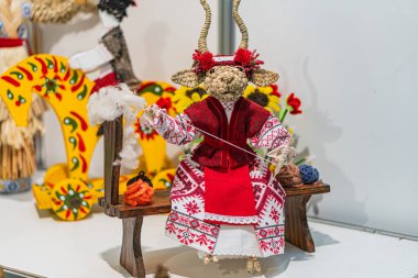 Canlı Ukrayna ulusal oyuncağı, geleneksel giyimli kırmızı ceketli bayram bebeği, yeşil ve beyaz desenli pantolon, tüylü kırmızı şapka, ipli bir enstrüman, dans ya da müziği çağrıştıran