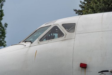 Tek motorlu eski bir uçak, bulutlu bir günde açık havada, kokpit pencereleri açık, kanat sola doğru uzanıyor ve uçta küçük kırmızı bir çarpışma önleyici ışık var.