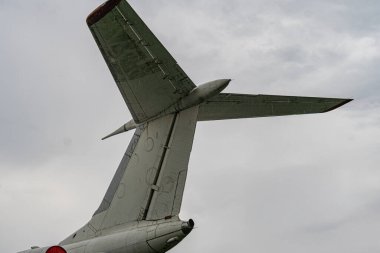 Gri ya da açık mavi pervaneli bir uçağın ön planı, kuyruğu görünür açık gökyüzü arkaplanı, yüksek bulutlar, mevcut insan yok.