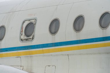 Havaalanı pistinde büyük beyaz ve mavi-turuncu çizgili jet uçağı görünür motorlar, iç aydınlatmayı gösteren ön kapı, tanımlayıcı bir iz yok.