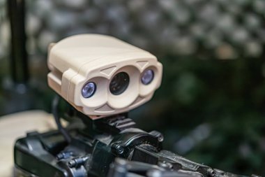 Robot mayından arındırma kolu, yeşillik, ten rengi mekanik yapı, çift lensli ya da sensörlü kamera, doğal ışıklandırma...