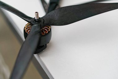 Siyah pervane bıçakları ve sarı bilyalı merkez, muhtemelen bir savaş kuadkopter drone parçası Doğal ışıklandırma, yumuşak gölgeler