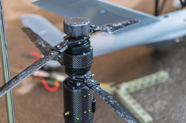 Dörtlü savaş robotunun görüntüsü, merkezde, ön monte edilmiş bir telle konumlandırılmış. Çemberin birden fazla LED lambası ve siyah koruyucu kefeni var. Bu da bir kamera ya da sensör montajı olduğunu gösteriyor.