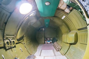 İçinde yeşil-mavi ışıklandırmalı metalik duvarlar bulunan bir uzay aracının iç görüntüsü astronotlar için hizalanmış, her iki taraf da ön tarafa doğru gidiyor kontrol sistemi yapısı ve...