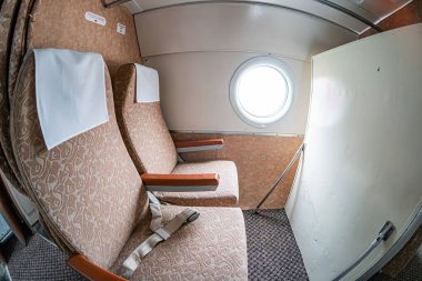 Küçük, küçük, kompakt uçak kokpiti kontrol ve aletlerle bej döşeme ve beyaz desenli koltuk parlak, gündüz aydınlatmalı aydınlatma boş kokpitin iç mekânında bir yolcu hava aracının gizli fotoğrafını saklar