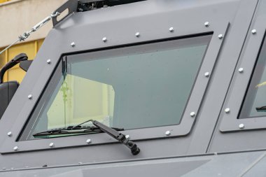 Zırhlı mayın temizleme aracı, sessiz gri, kutu şeklinde, yuvarlak köşeler, güçlendirilmiş pencereler, gözlem noktası, kamuflaj, özel bir marka ya da model yok, tanımlanamayan arka plan, açık hava ayarı