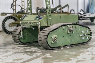 Yeşil, güçlü, tank benzeri izleri olan küçük bir askeri robotun kapalı bir görüntüsü, muhtemelen Ukraynalı. Özel bir model ya da isim yok..