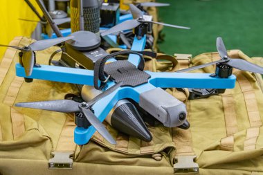 Mavi ve siyah Ukrayna FPV İHA 'sı bej renkli bir çantada, kayışları var, çevre ışığı altında dinleniyor..