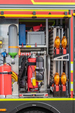 İtfaiye araçları, hortumlar, hortumlar, bağlantıları olan itfaiye kamyonu ve görünür bir oksijen tankı.