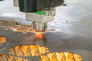 Endüstriyel bir sürecin yakın görüntüsü, hassas iş yapan bir makineye odaklanma muhtemelen mikro elektronik veya devre kartı montajı, parlak ışık altında kıvılcım etkisi yaratan, bulanık torba