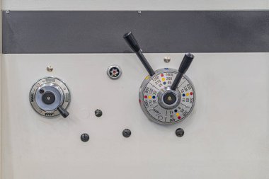 İki dairesel kadranlı endüstriyel kontrol panelinin yakın çekimi trafik ışığı sistemine benzeyen bir ekran ve siyah metal çerçeveye monte edilmiş arka planda beyaz bir şerit var.