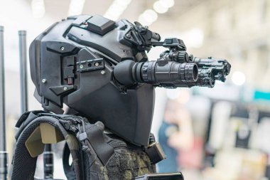 Mekanik eklemleri olan, parlak siyah, gelişmiş insansı bir robotun yakın plan görüntüsü, yüksek teknolojili bir silah taşıyor.