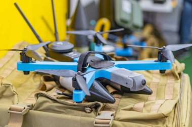 Yayılmış yapay ışık atölyesinde dört pervaneli gri-mavi bir dronun yakın plan görüntüsü..