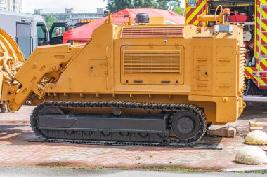 Düz olmayan kırmızı tuğla yüzeye park edilmiş büyük sarı buldozer, siyah raylar, inşaat aracı, sarı, düzensiz, kırmızı tuğlalar, ağır iş, insan ya da dikkate değer nesneler yok, hafifçe yükseltilmiş açı, ışıklandırma.,