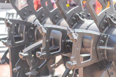 Metalik bir maden temizleme makinesinin ya da bir kısmının yakın görüntüsü, doğal ışık ile karışık dişli ve silindir ayarı ile hasat bileşenine benzer.