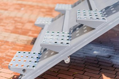 Tuğla yüzeyindeki metal plakaların yakın görüntüsü, inşaat ya da bakım projesinin bir parçası, perçinli kenarlar, doğal aydınlatma gölgeleri