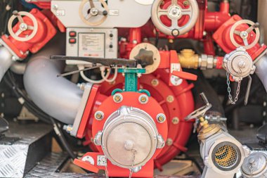 Kırmızı motorlu itfaiye aracı veya kurtarma aracı, yeşil valf, hidrolik pompa, metalik borular, ön planda pencere veya kapı yok