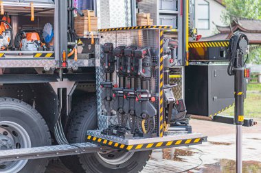 Su ve benzin için etiketlenmiş, açık bir yerleşim alanına park edilmiş, faydacı, koyu renkli kamyonun yakın plan görüntüsü yağmurlu ve nemli olduğunu gösteriyor.