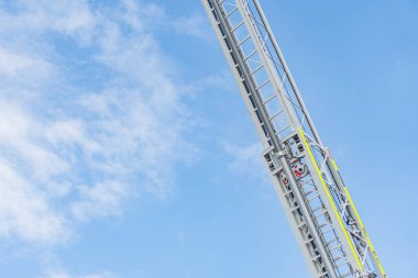 Kurtarma operasyonunda itfaiye aracı kaldırma, hava merdiveni genişletilmiş, dış mekan ayarları, gün ışığı, tanımlanamayan şahıslar, gizli fotoğraf tarzı.
