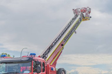 Geniş sarı uçlu itfaiye aracı, 97 numara, açık alana park edilmiş, bulutlu gün, gerçekçi stil, insan ya da yakınlarda başka önemli nesneler yok.