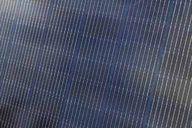 Güneş panellerini tekrar eden ince yapılarla yakın plan, muhtemelen lensler veya filtreler, gri ve siyah tonların hakim olduğu bastırılmış renk paleti aydınlatma bir ışık ve şah oyunu olduğunu gösteriyor.