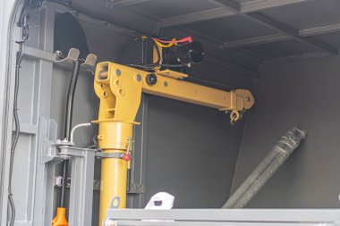 Endüstriyel metal yapıların egemen olduğu bir kurtarma aracının iç görüntüsü ve büyük bir sarı-siyah makine parçası.
