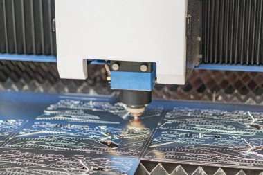 Endüstriyel lazerin yakın çekim görüntüsü, taşıma sistemi üzerindeki devre kartından yükleyici bileşen yükleyen robotik kol karmaşık desenlere ve çok renkli bileşenlere sahiptir.