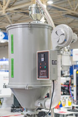 Büyük endüstriyel mixerprocessor, silindirik tabanlı ve iki gümüş tanklı, kapalı bir sanayi ortamında, yapay ışıklandırma, insan yok, metalik renkler, mavi bileşenler, fonksiyonel stil, yan v