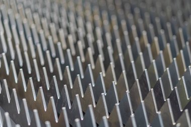 Koyu metalik bir ızgaranın yakın görüntüsü, tek kare çıkıntıları, hatta yukarıdan aydınlatma bile var..