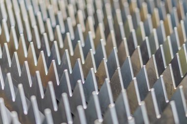 Yığılmış yüzeyli metal plakaların yakın çekimi, endüstriyel makinelere ya da ısı değişim bileşenlerine benziyor gümüş-griden koyu tonlara kadar markalaştırma açısı, teknik ve aydınlatma açısı yok.