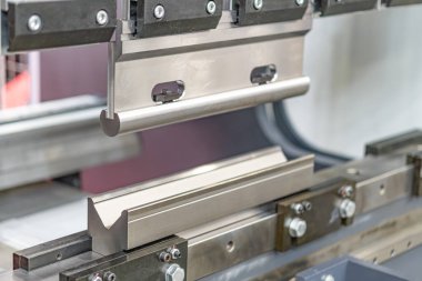 Düz çubuklar, açısal parantezler ve objeler gibi dairesel makara gibi çeşitli bileşenler içeren metal montaj hattının yakın plan görüntüsü.